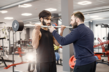 indian-man-doing-excercisses-special-equipment-gym-with-personal-trainer 1